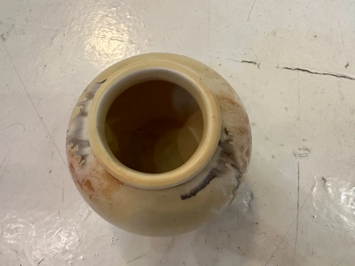 Antique ceramic jar with earthy tones and unique patterns.