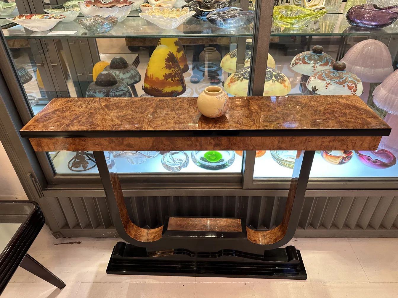 Antigua cerámica artesanal en una mesa elegante, con fondo de vidrio.