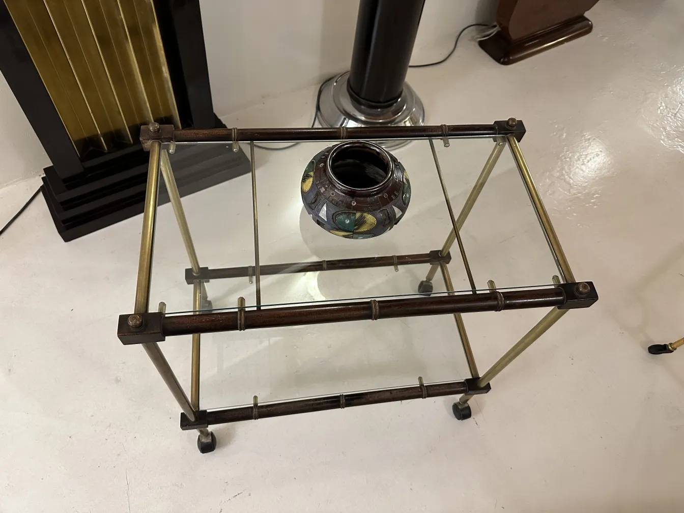 ガラスのテーブルの上にあるカラフルなデザインの古い陶器の花瓶。