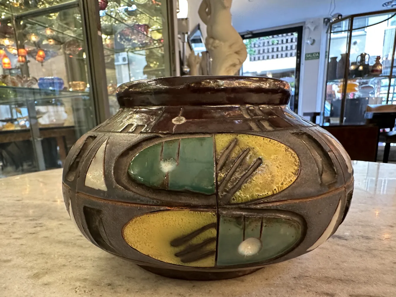 Vaso in ceramica antica con decorazioni verdi e gialle