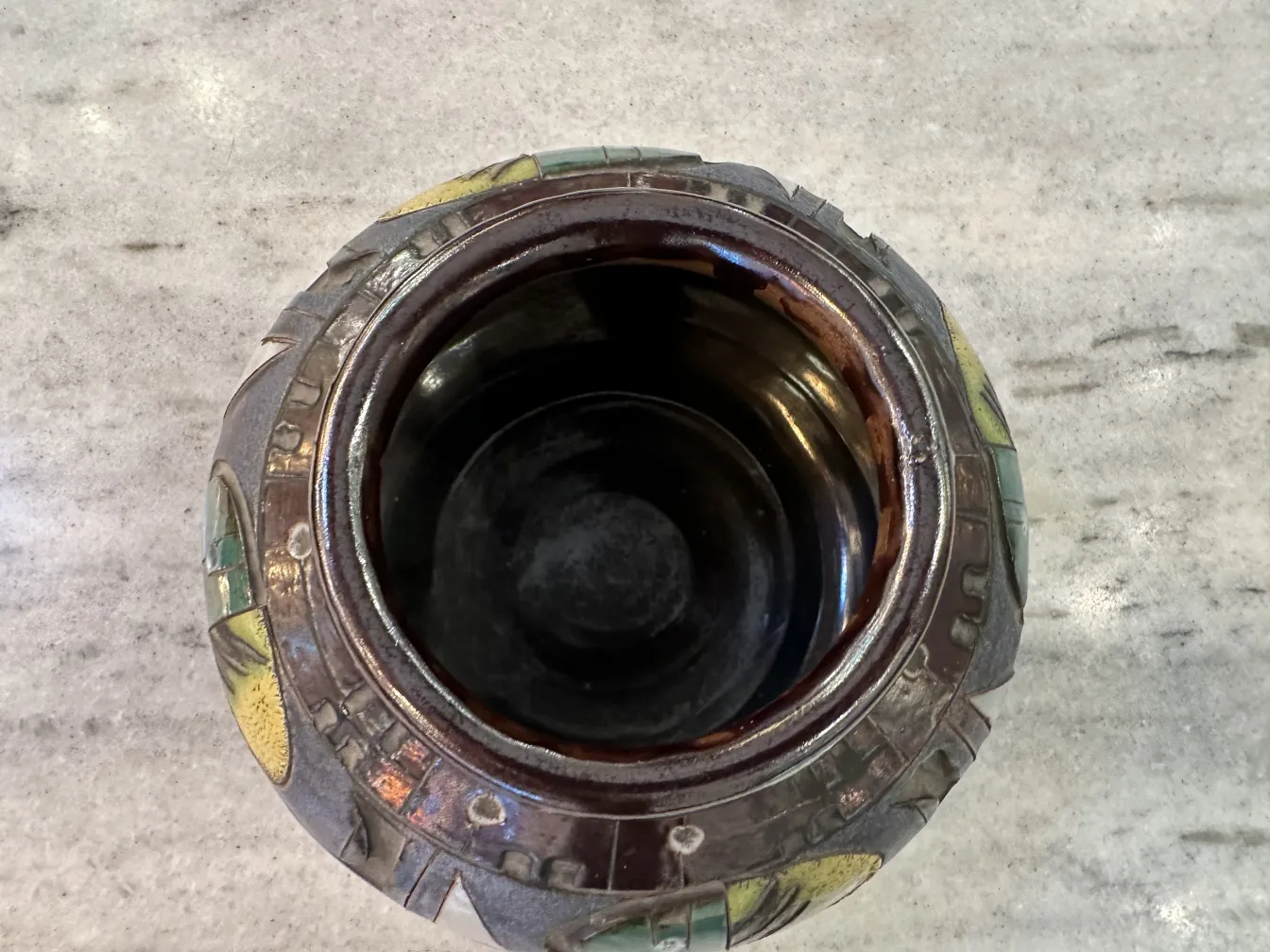 Vaso in ceramica antica con decorazioni vivaci e forma rotonda su sfondo in marmo