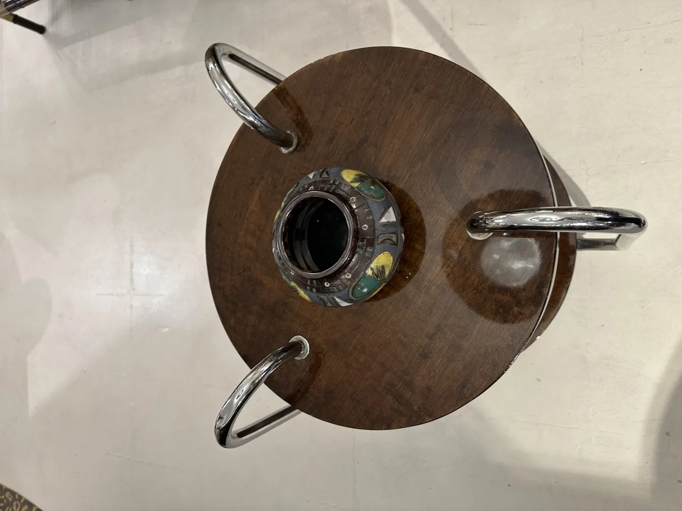 Cerámica antigua con detalles coloridos sobre una mesa de madera