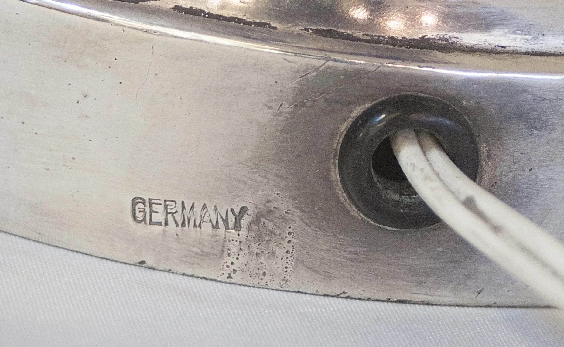 sello antiguo con marcas, fondo claro y cordón