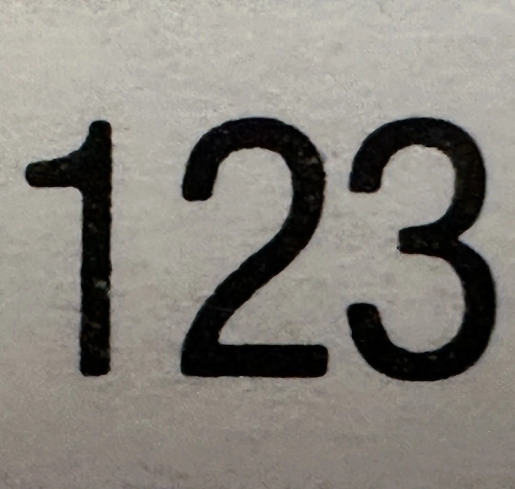 Antiguo sello con números visibles, detalle claro y definido.