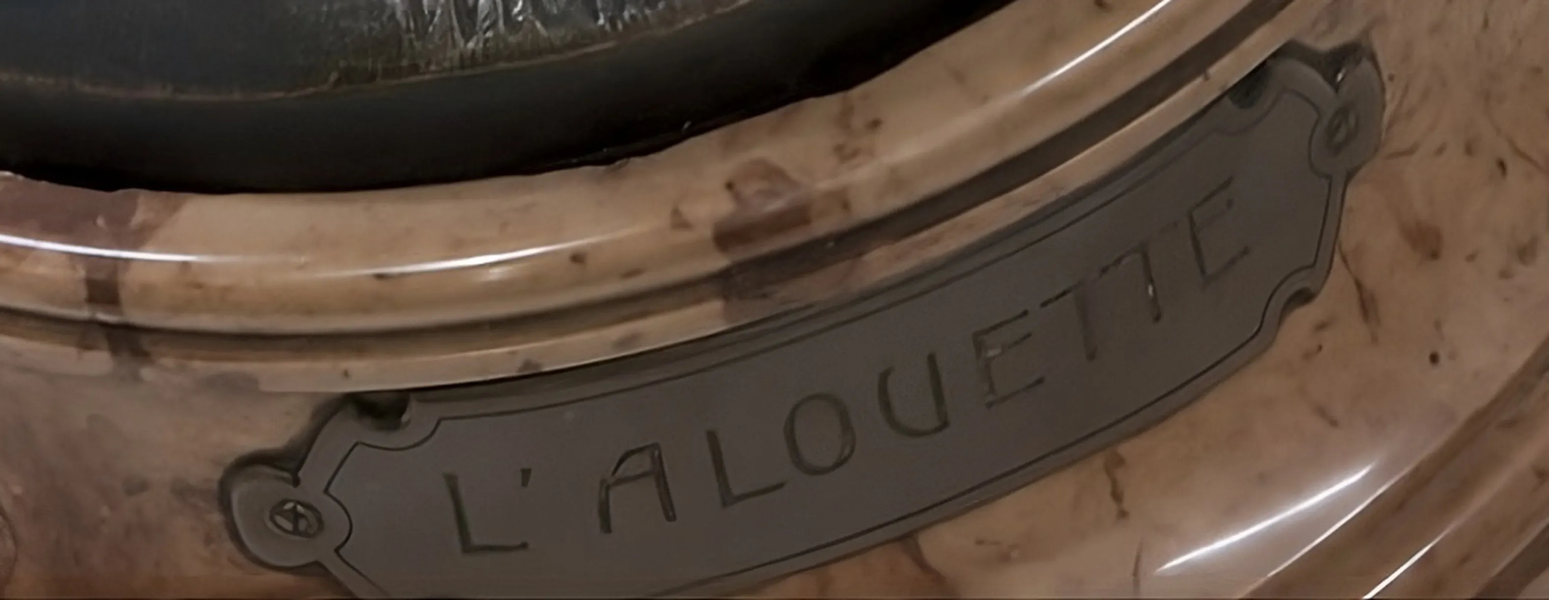sello antiguo con inscripción l´alouette en un fondo decorativo