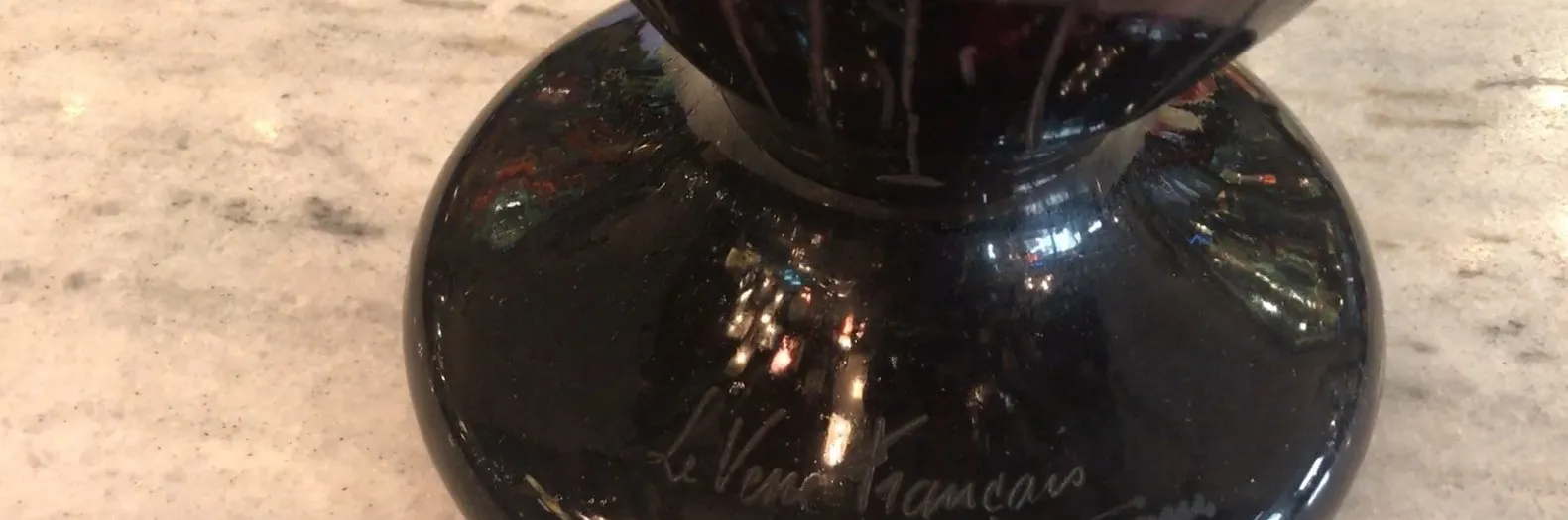 sceau antique Le Verre Français sur une surface claire, réfléchissant la lumière