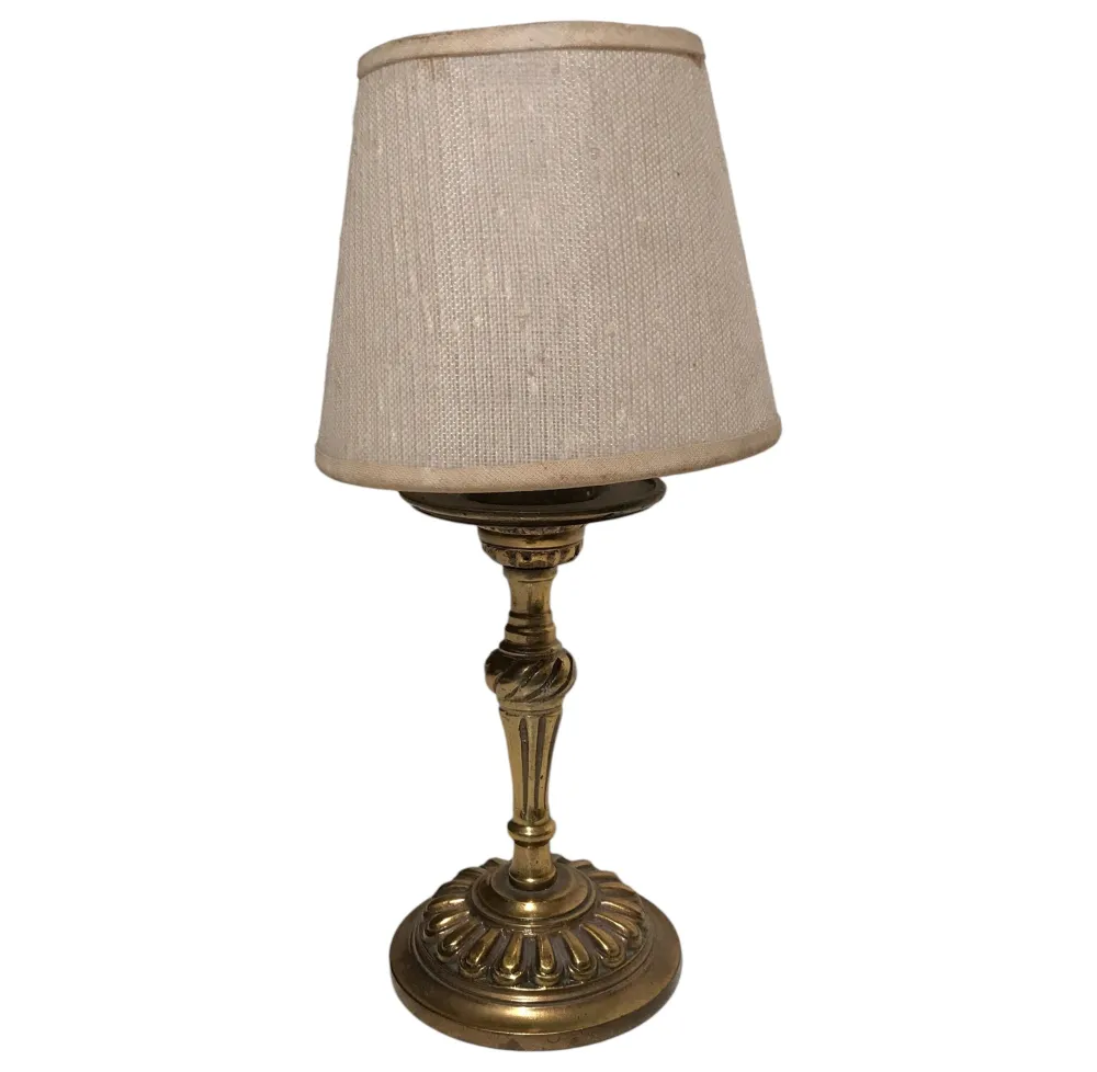 Lampada da tavolo antica con paralume beige, ambiente accogliente.