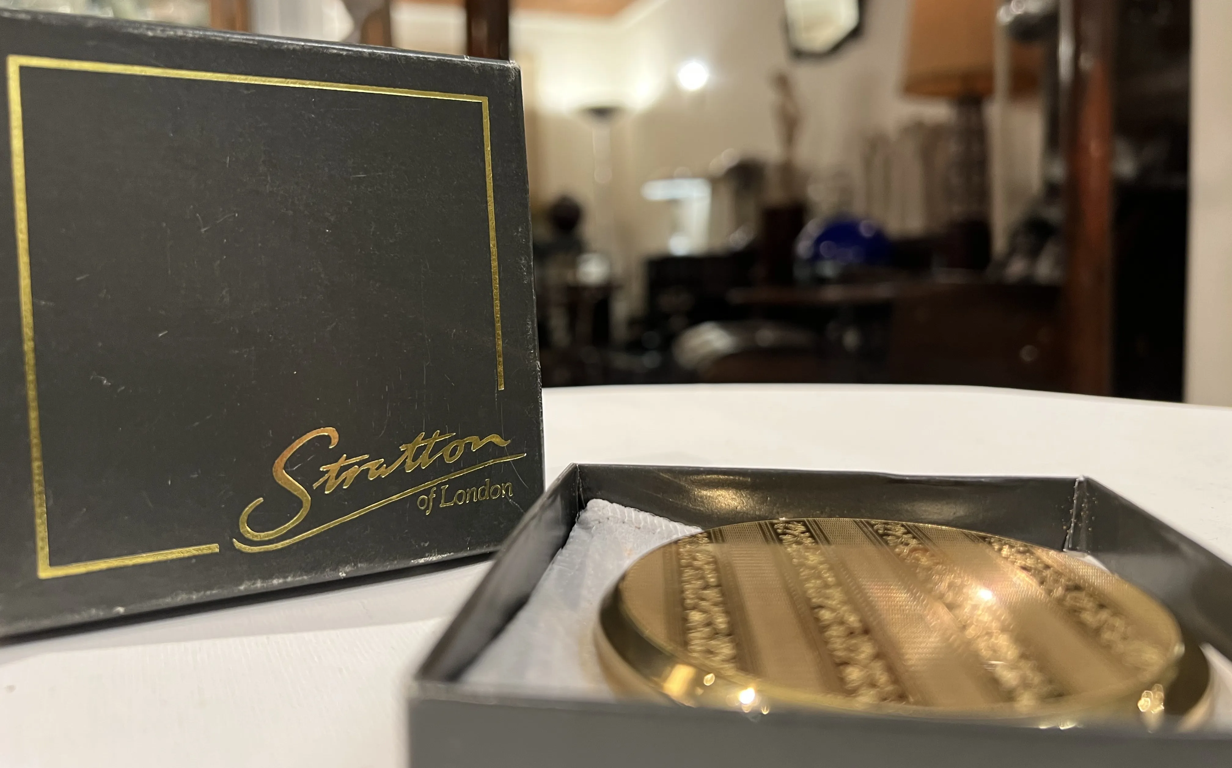 Stratton of London의 고대 도장이 상자에 들어 있으며, 장식적인 디자인.