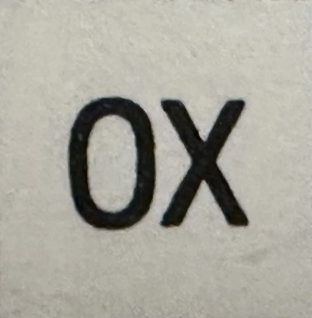 Античная печать с надписью 'OX', светлый фон, пример старины.