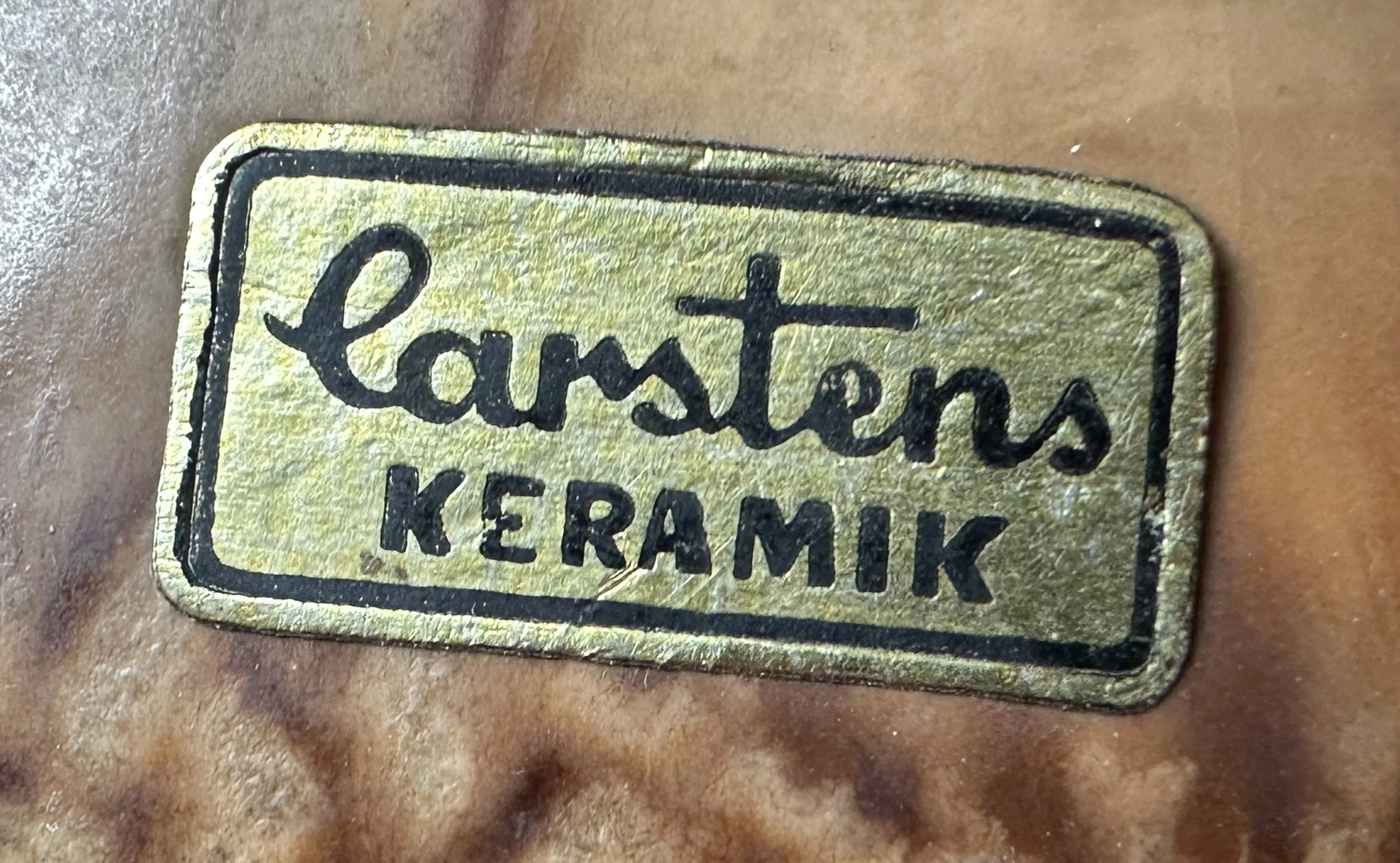 старинная печать с брендом Carstens Keramik в золотом и черном на коричневом фоне