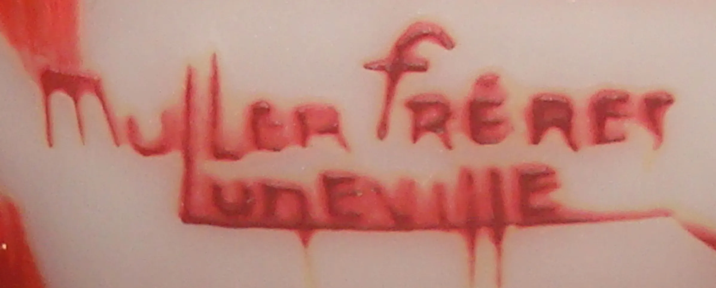 ختم قديم بكلمات Muller frères Luneville باللون الأحمر على خلفية فاتحة